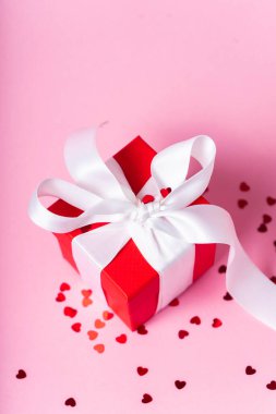 Beyaz kurdeleli küçük kırmızı hediye kutusu.