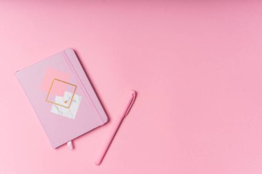 Seçici odaklanma. Sevgililer Günü planı. Kopyalama alanı olan pembe bir not defteri. Kırtasiyeli pembe kâğıt arkaplanda. Yukarıdan görünüm