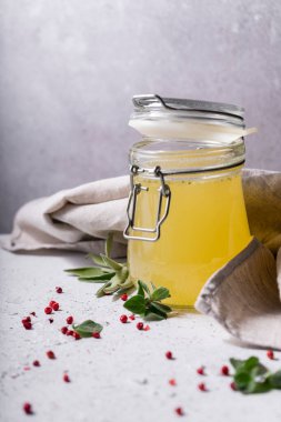 Seçici odaklanma. Cam kavanozda ev yapımı sığır eti çorbası. Açık gri arka planda. Baharat-tuz ve biber eklenerek. Kemikler kolajen içerir, bu da vücuda amino asit sağlar.