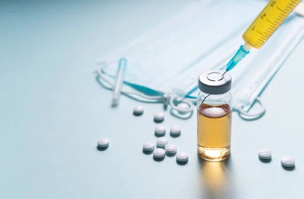 Seçici odaklanma. Aşıyla birlikte tek kullanımlık bir şırınga, virüsten bir serum. Covid-19 ve mevsimsel hastalıklar için antiviral ilaç. Düz çizgi