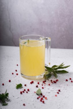 Seçici odaklanma. Şeffaf kupada ev yapımı sığır eti çorbası. Açık gri arka planda. Baharat-tuz ve biber eklenerek. Kemikler kolajen içerir