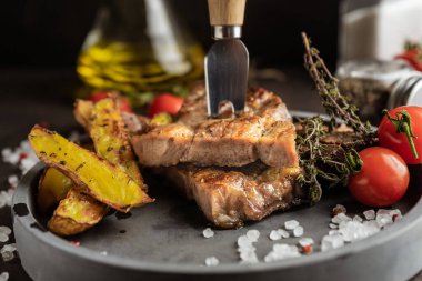 Seçici odaklanma. Köy usulü kızartılmış domuz bifteği. Ahşap bir tahtanın üzerinde, kaba tuz ve baharatlarla. alçak tuş, yakın plan