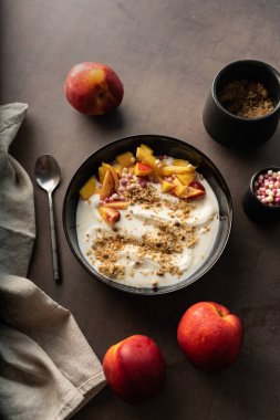 Seçici odaklanma. Sabah kahvaltısı. Meyveli yoğurt ve müsli. Sağlıklı yemek. Üst manzara, derin gölgeler. Doku. alçak tuş, kopyalanmış boşluk