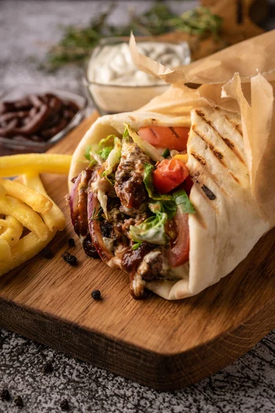 Taze sebze ve et çukurunda bir shawarma. Büyük baharatlarla. Restoran servisi. Karanlık bir arka planda. Menüler ve reklamlar için