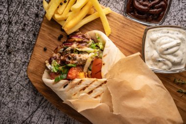 Taze sebze ve et çukurunda bir shawarma. Büyük baharatlarla. Restoran servisi. Karanlık bir arka planda. Menüler ve reklamlar için