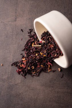 Seçici odaklanma, doğal siyah yaprak çayı. Kil kasesinde demleniyor. Dikey açı, makro. Karanlık bir arka planda. Menüler ve kafeler için