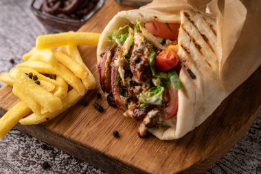 Taze sebze ve et çukurunda bir shawarma. Büyük baharatlarla. Restoran servisi. Karanlık bir arka planda. Menüler ve reklamlar için