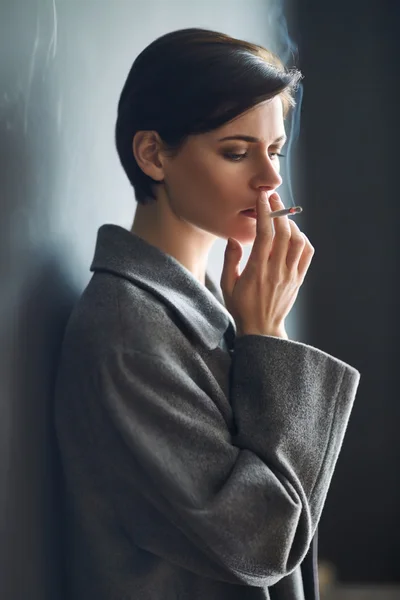 Fashionable woman smoking cigarette — Stock Photo, Image