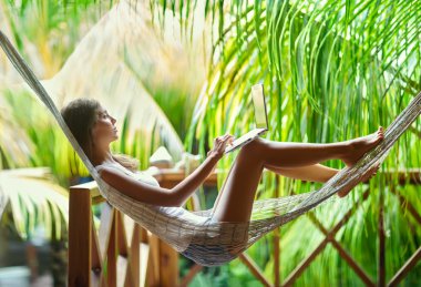 Dizüstü bilgisayar ile bir hamakta kadın