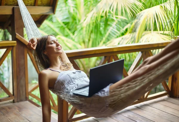 Mulher relaxante em uma rede — Fotografia de Stock