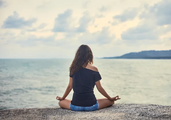 Mulher meditando no penhasco — Fotografia de Stock