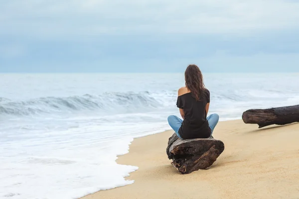 Kobieta siedząca na plaży — Zdjęcie stockowe