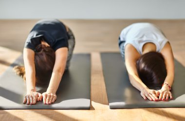 Asana Childs'ın yoga yaparken iki genç kadın poz