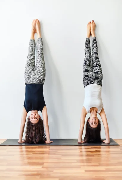 Dwóch młodych kobiet robi joga handstand stanowią — Zdjęcie stockowe