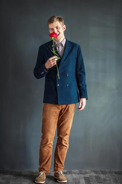 Homem engraçado comendo rosa vermelha — Fotografia de Stock