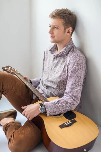 Bărbat frumos cu chitară așezat pe podea — Fotografie, imagine de stoc