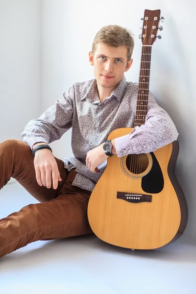 Handsome man with guitar sitting on floor — Stock Photo, Image