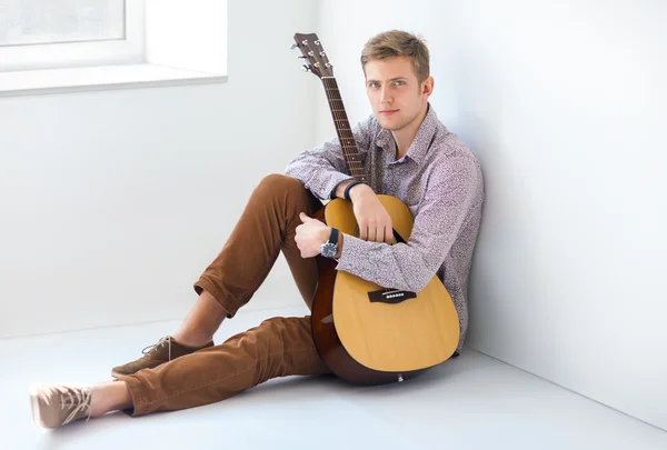 Man with guitar sitting on floor — Stock Photo, Image