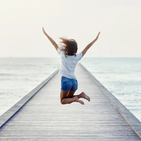 Rückansicht des springenden Mädchens auf Pier — Stockfoto