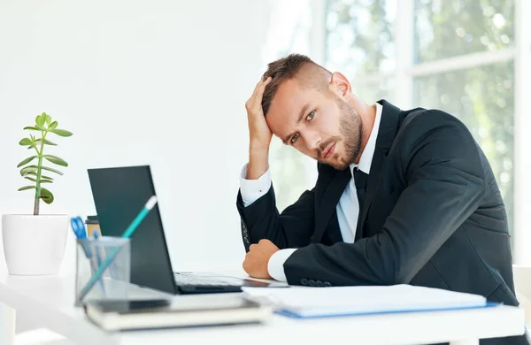 Hombre de negocios cansado estresado sentado en el escritorio en la oficina creativa — Foto de Stock