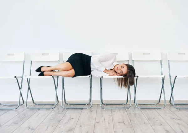 Exagerada mulher de negócios cansada dormindo na cadeira na sala de conferências — Fotografia de Stock