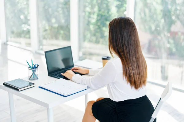 Vue arrière de la jeune femme d'affaires travaillant avec un ordinateur portable au bureau — Photo