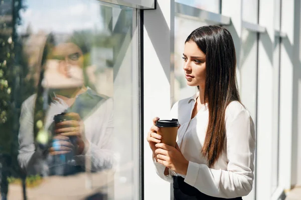 Egy elegáns üzletember portréja egy csésze kávéval a kezében a szünetben a modern kreatív irodában, fénymásoló térrel — Stock Fotó