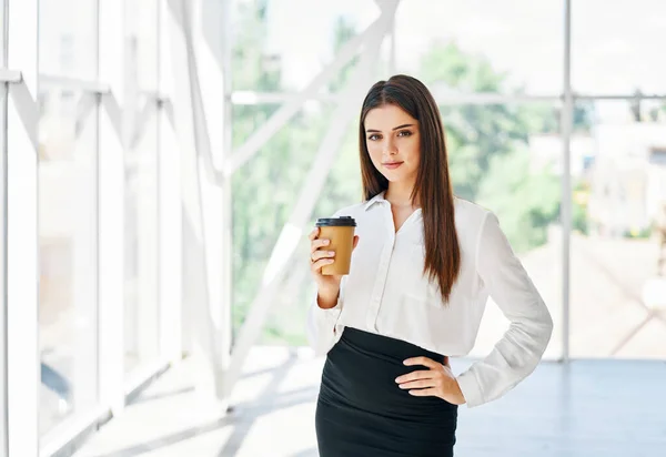 Porträt eines eleganten Geschäftsmannes mit einer Tasse Kaffee in der Hand in der Pause im modernen Kreativbüro — Stockfoto