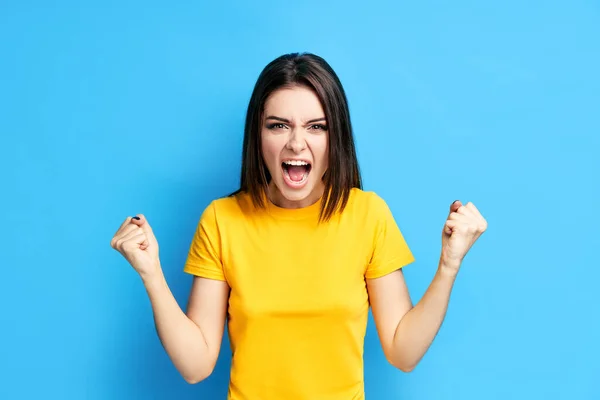 Gritando emocional raiva jovem mulher no fundo azul — Fotografia de Stock