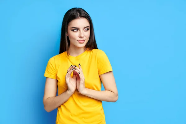 Mulher bonita Sly tem plano interessante em mente, olha para o fundo azul — Fotografia de Stock