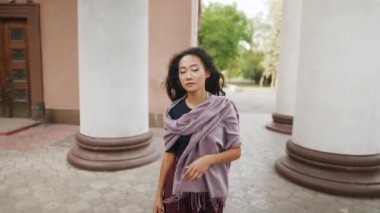 Sütunlar boyunca yürüyen güzel Asyalı kadın.