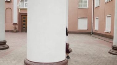 Dışarıdaki sütunlarda yürüyen güzel Asyalı kadın profili.