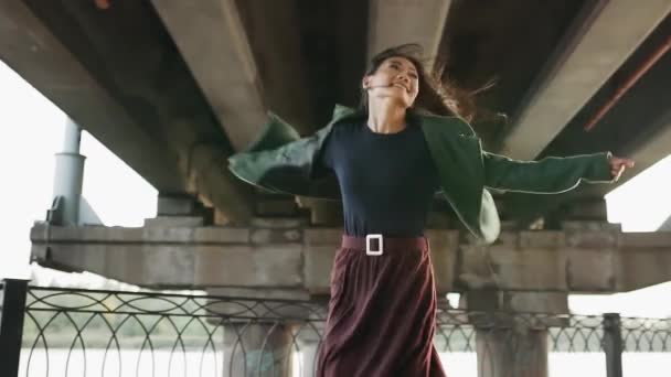 Felice sorridente donna asiatica filatura all'aperto sotto ponte urbano — Video Stock