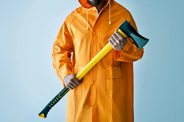 Imagem cortada do homem em capa de chuva brilhante segurando grande machado — Fotografia de Stock