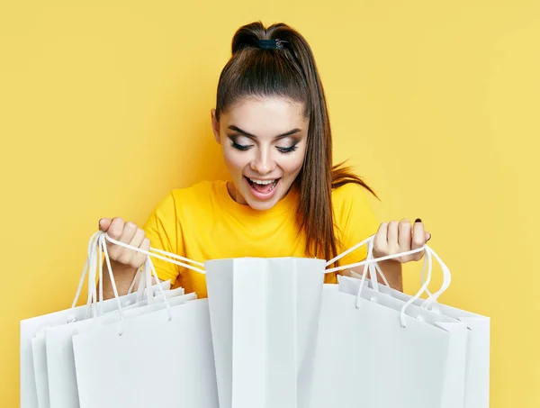 Emocionado mujer feliz sosteniendo bolsas de compras en las manos y mirando su compra —  Fotos de Stock