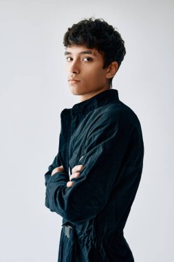 Young trendy mixed race man with crossed arms posing on white background