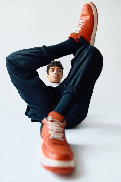 Junger trendiger Mischling posiert im Studio auf dem Boden liegend auf weißem Hintergrund — Stockfoto