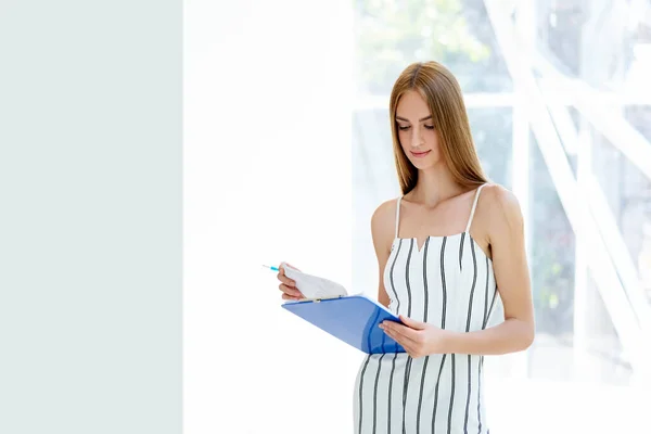 Mooie zakenvrouw die documenten leest in haar moderne kantoor — Stockfoto