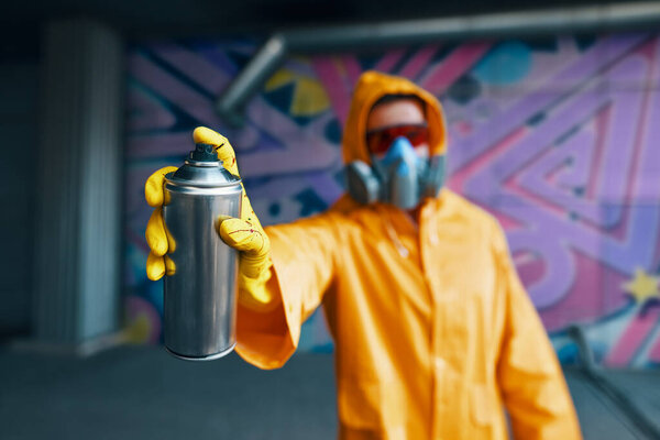 Graffiti artist pointing spray paint can to camera