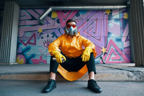 Graffiti painter rest near the wall with his paintings looking to camera — Stock Photo, Image