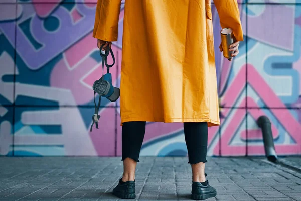 Imagem cortada de artista de rua com spray lata de tinta na mão de pé perto da parede — Fotografia de Stock