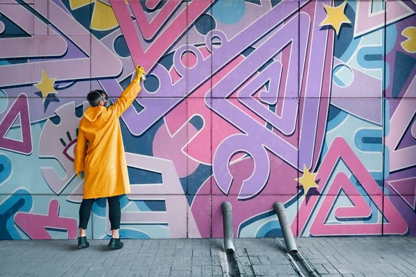 Pouliční malíř malovat barevné graffiti na zeď — Stock fotografie