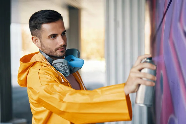 Street artist måla färgglada graffiti på väggen — Stockfoto