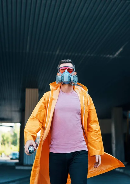 Trendy young man in respirator mask walking down the street — Stock Photo, Image