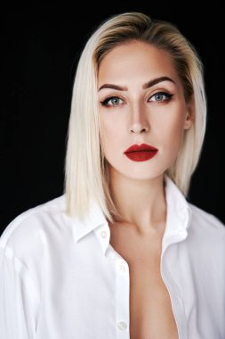 Siyah arka planda izole edilmiş, zarif beyaz gömlekli, kırmızı dudaklı güzel sarışın kadının portresini kapat..