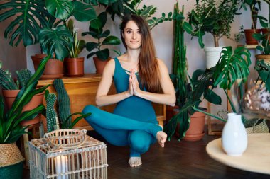 Genç sporcu kadın yoga yapıyor. Ayak parmaklarının yarısını dengede tutuyor.