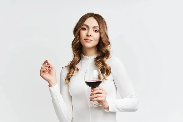 Pretty fashion woman holding glass of red wine on white background — Stock Photo, Image