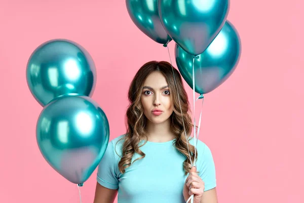 Close up portrait of happy pretty woman with blue balloons in hands on pink background — Stock Photo, Image