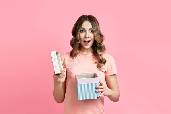 Excited smiling woman woman opening gift box over pink background — Stock Photo, Image