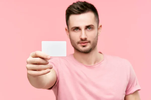 Egy fiatal férfi portréja, aki hitelkártyát mutat és kamerába néz — Stock Fotó